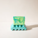 A step shaped concrete soap dish with a bar of soap sitting on it.