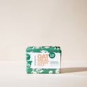 A bar of Oatmeal Chamomile soap wrapped in green packaging on a light background