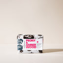 A bar of Peony and Amberwood soap with its packaging on a light background