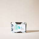A bar of R and R Soap with packaging on a light background